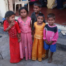 A picture of a group of young children standing together and smiling at the camera.