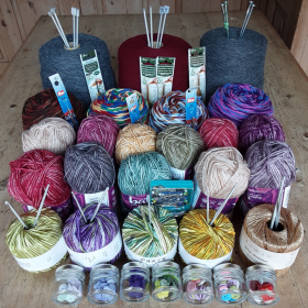 A collection of yarns, knitting needles and other haberdashery.