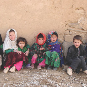 Group of children sitting on the ground against the wall