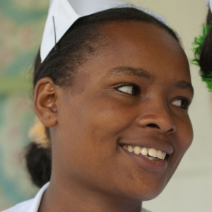 A young nurse is looking away from the camera and smiling