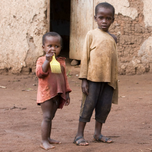 A picture of two young children wearing dirty, ragged clothes and looking at the camera.